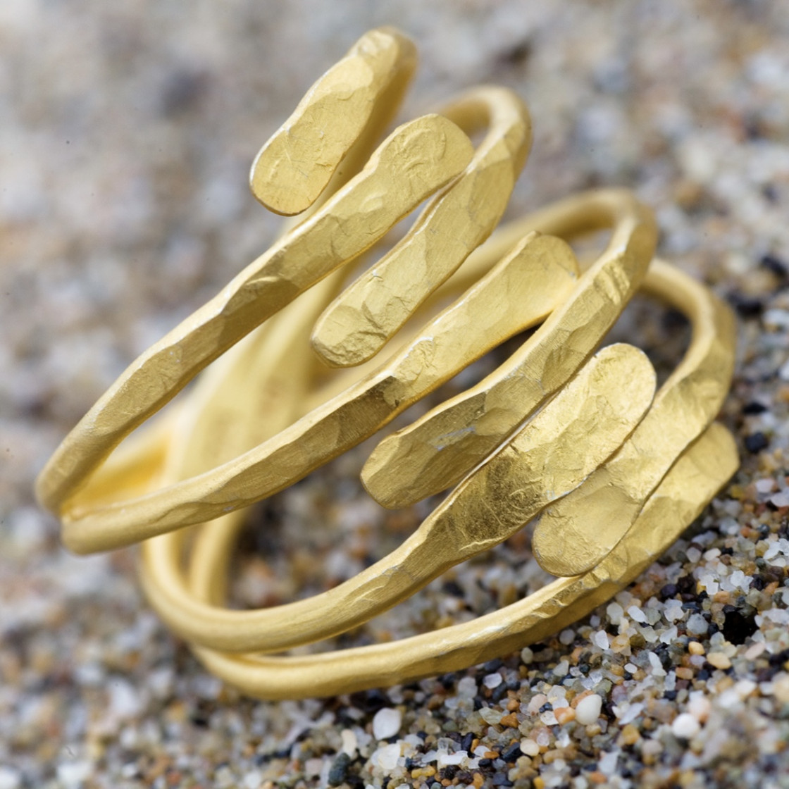 Eight slender hand hammered edges, meet in this wraparound attractively shaped gold ring.
