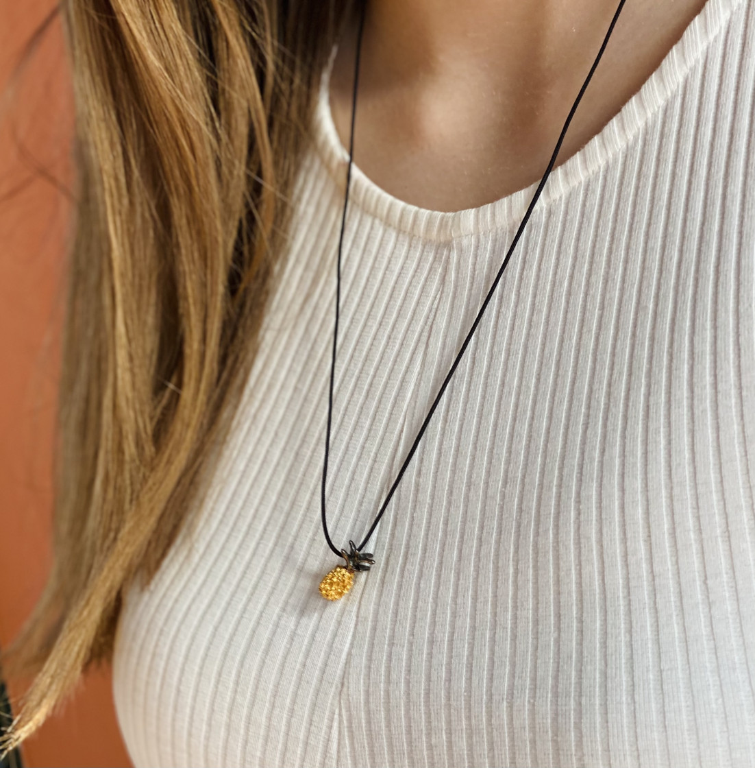 Unique pineapple pendant on a black adjustable cord.
