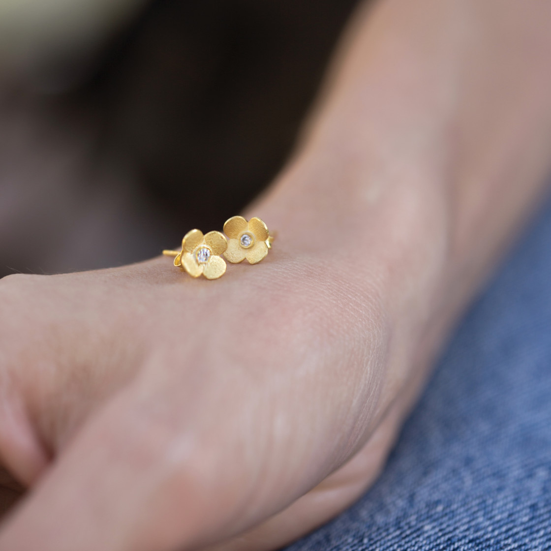 Gold handmade new blossoms accented with a zirkon stone.