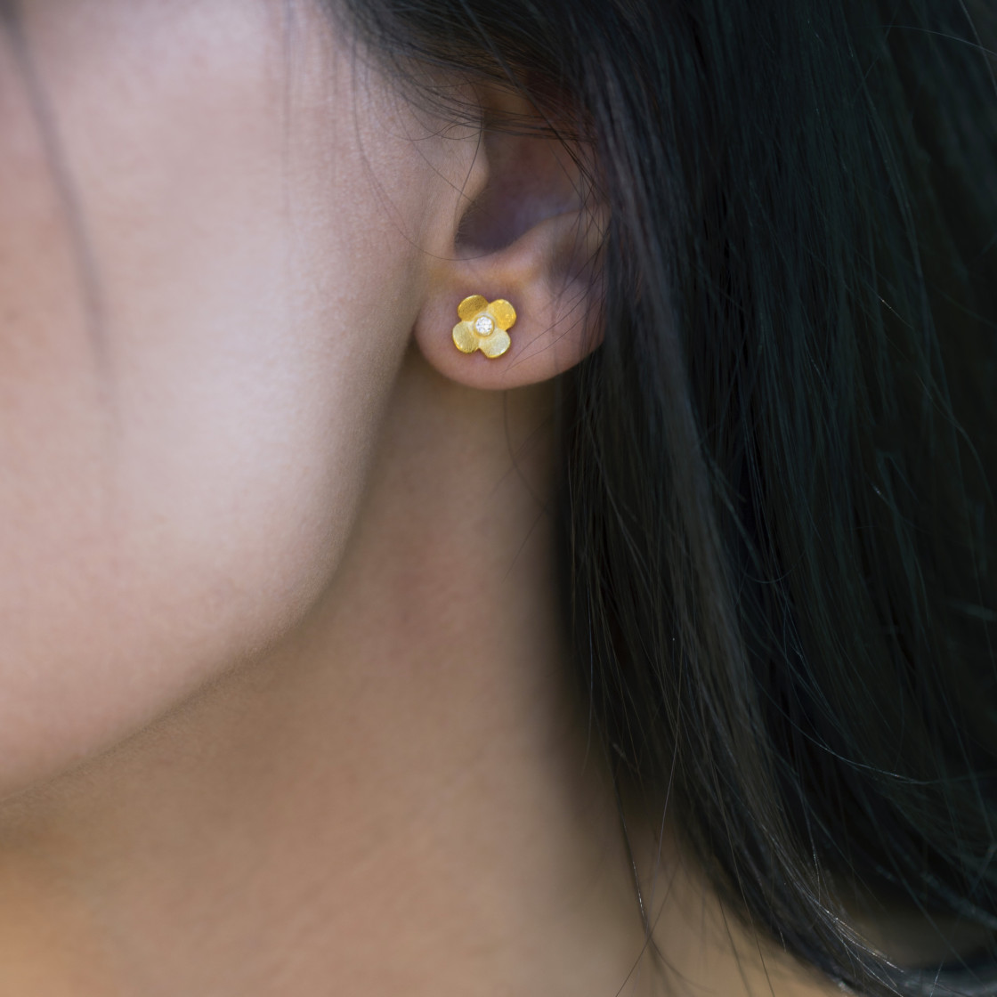 Gold handmade new blossoms accented with a zirkon stone.
