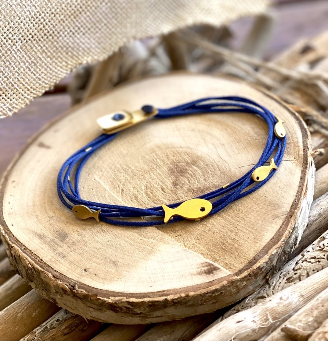 Gold fish tied to a multi strand of dark blue cords