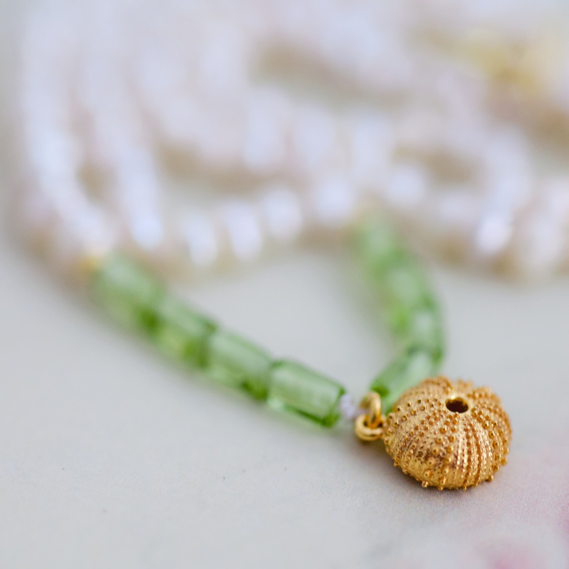 Elegant turquoise necklace with a gold starfish and a pearl.