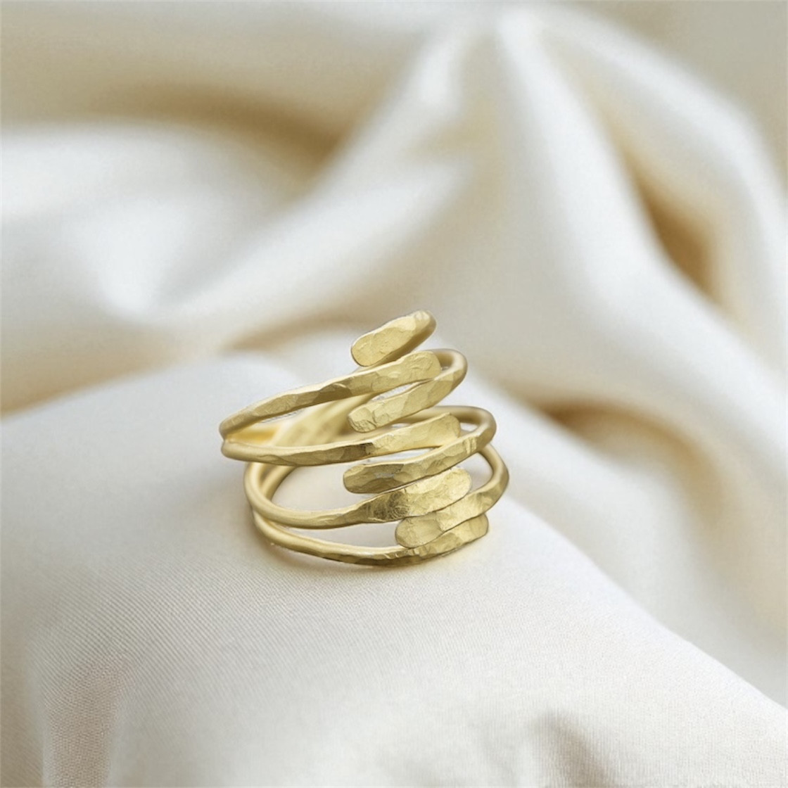 Eight slender hand hammered edges, meet in this wraparound attractively shaped gold ring.