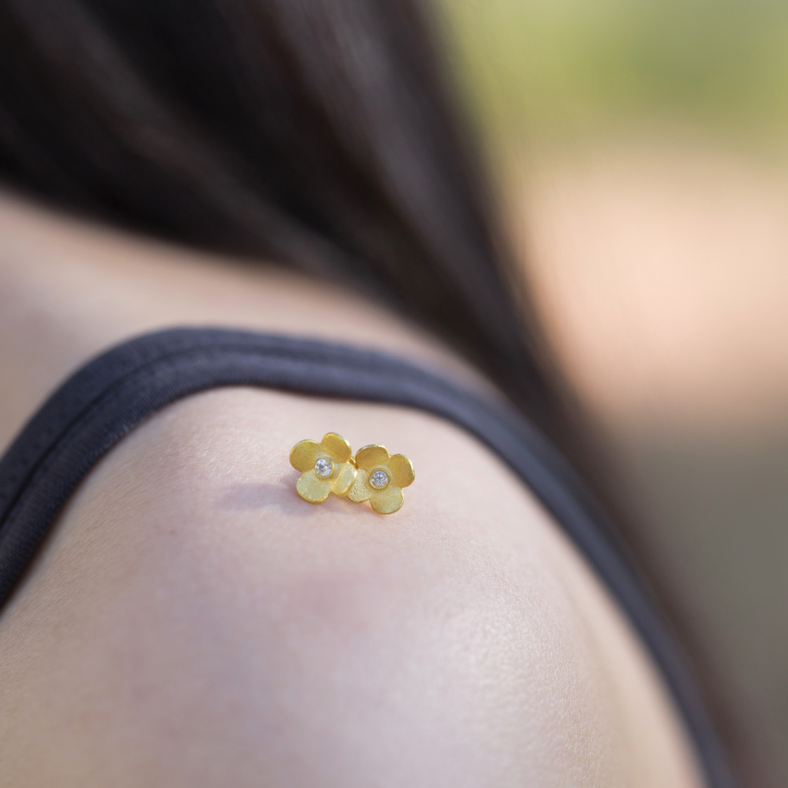 Gold handmade new blossoms accented with a zirkon stone.