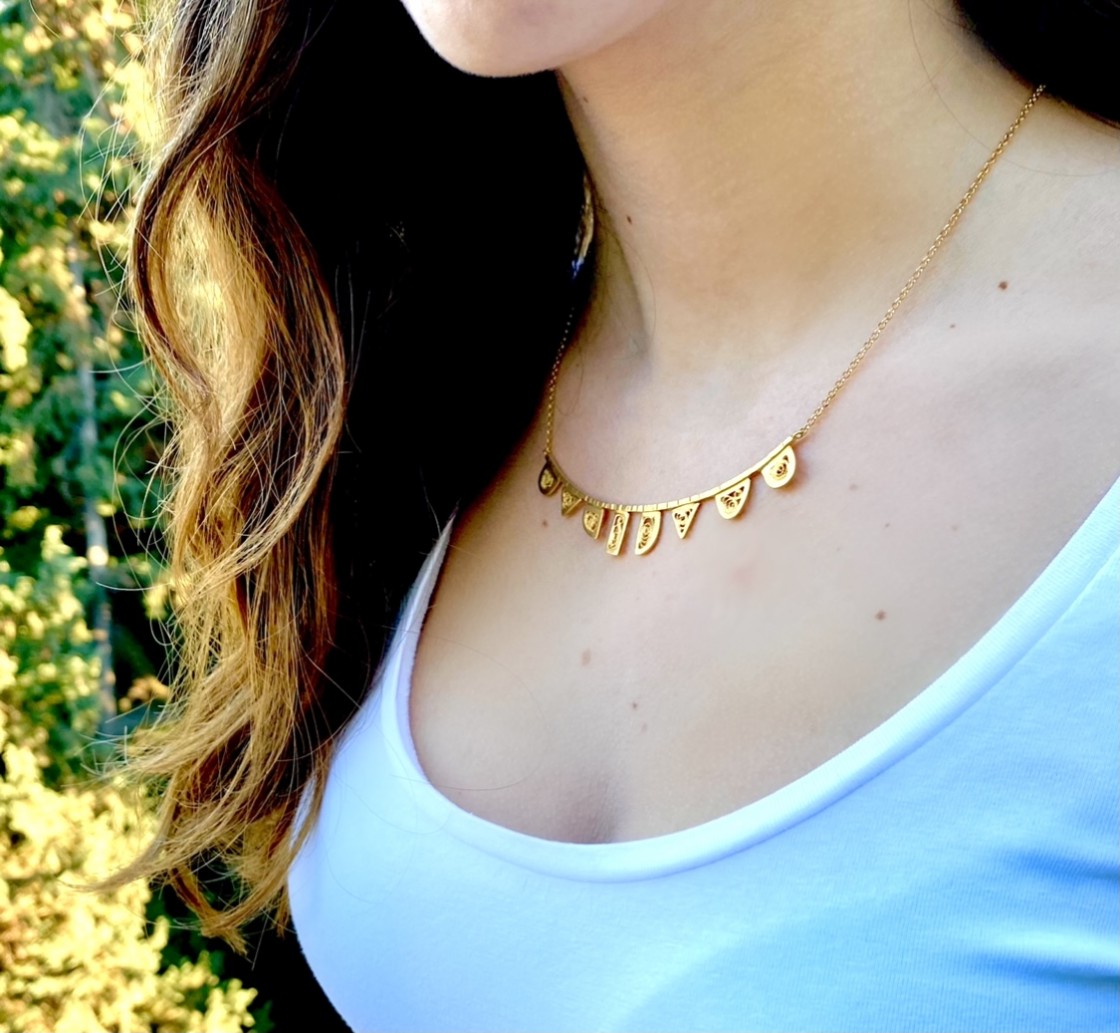 Eight elements, made with the traditional technique of filigree, mounted on a hammered bar, creating a necklace that illuminates the face and captures the eye.