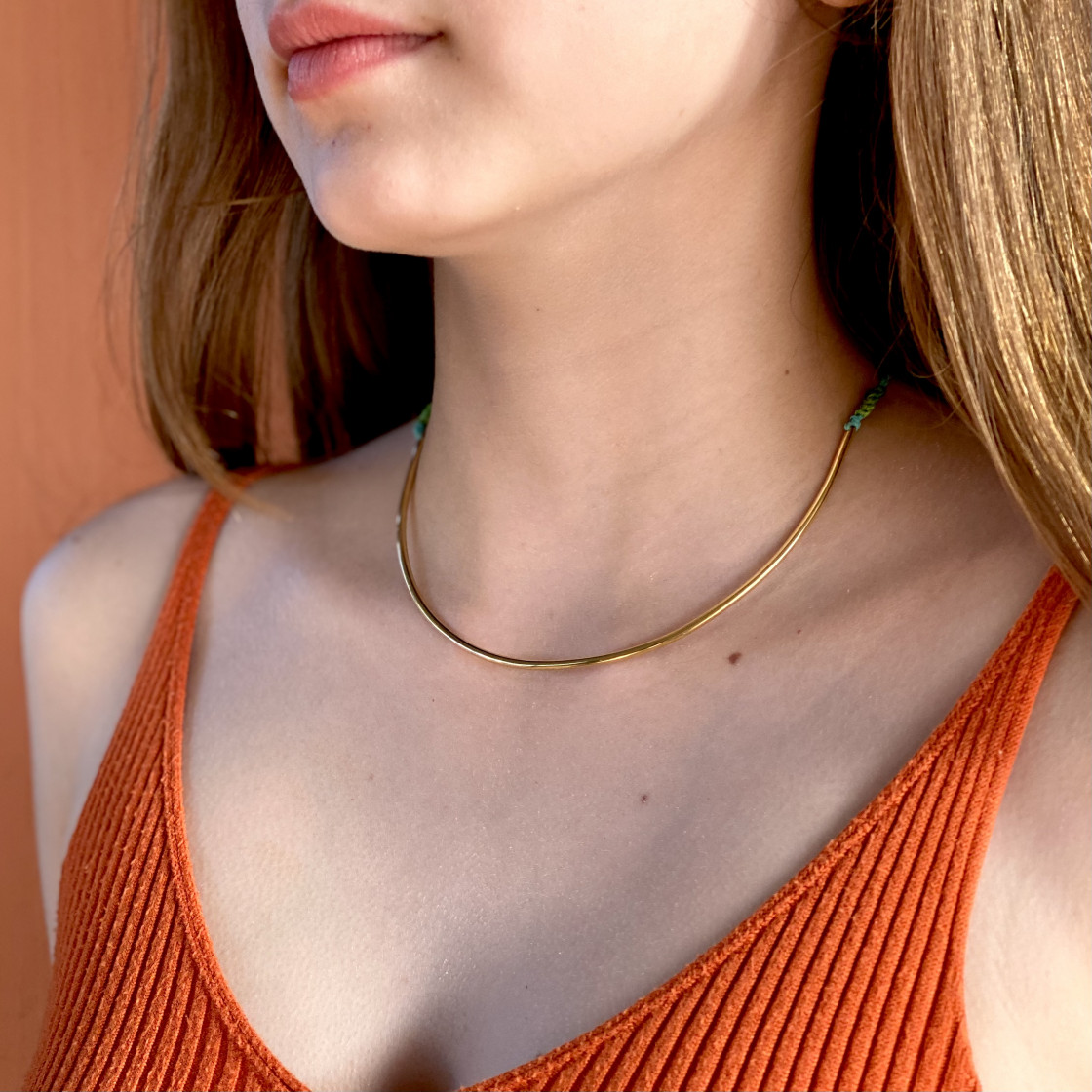 A beautifull and elegant shiny gold bar necklace on an adjustable cord