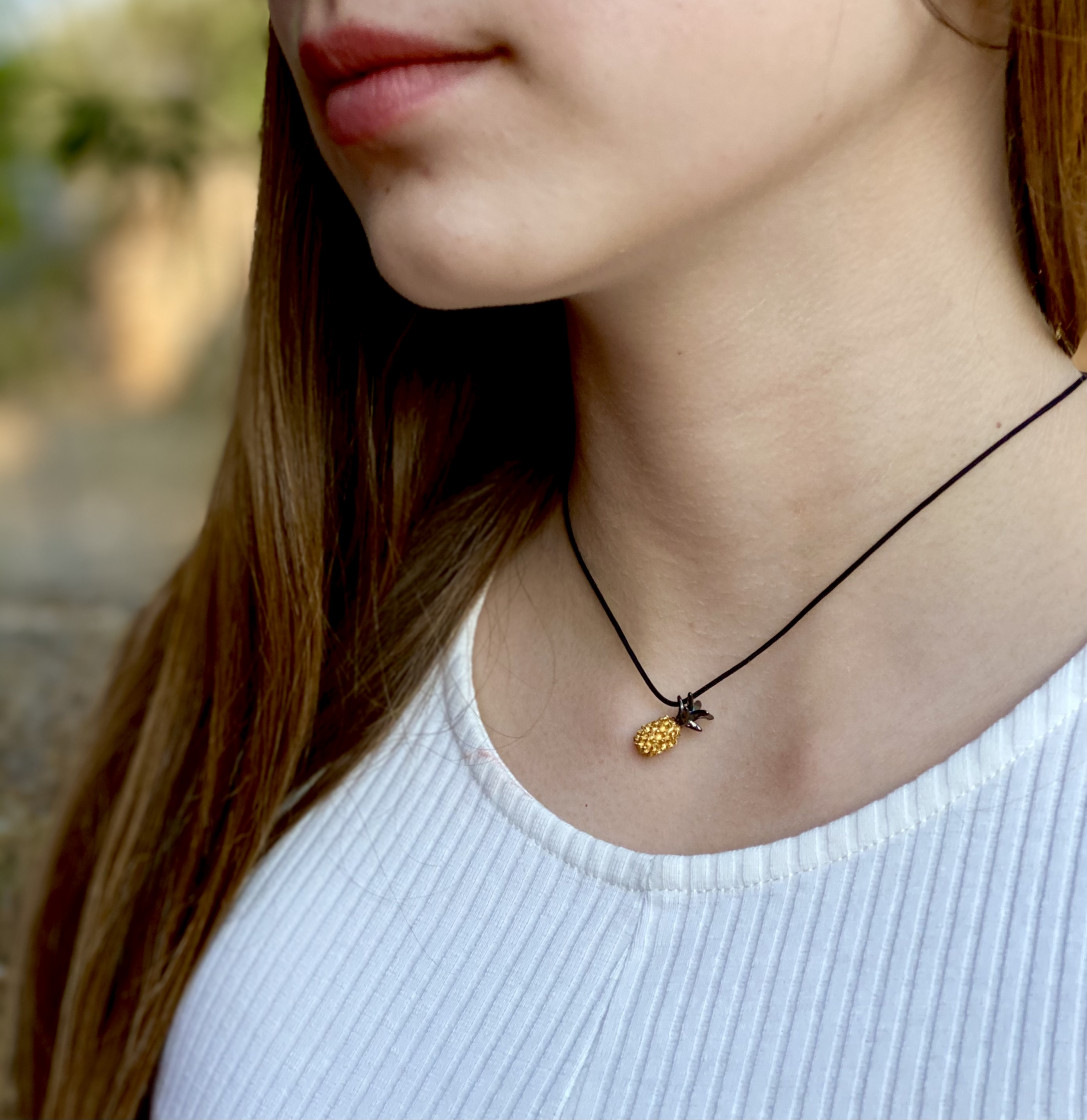 Unique pineapple pendant on a black adjustable cord.