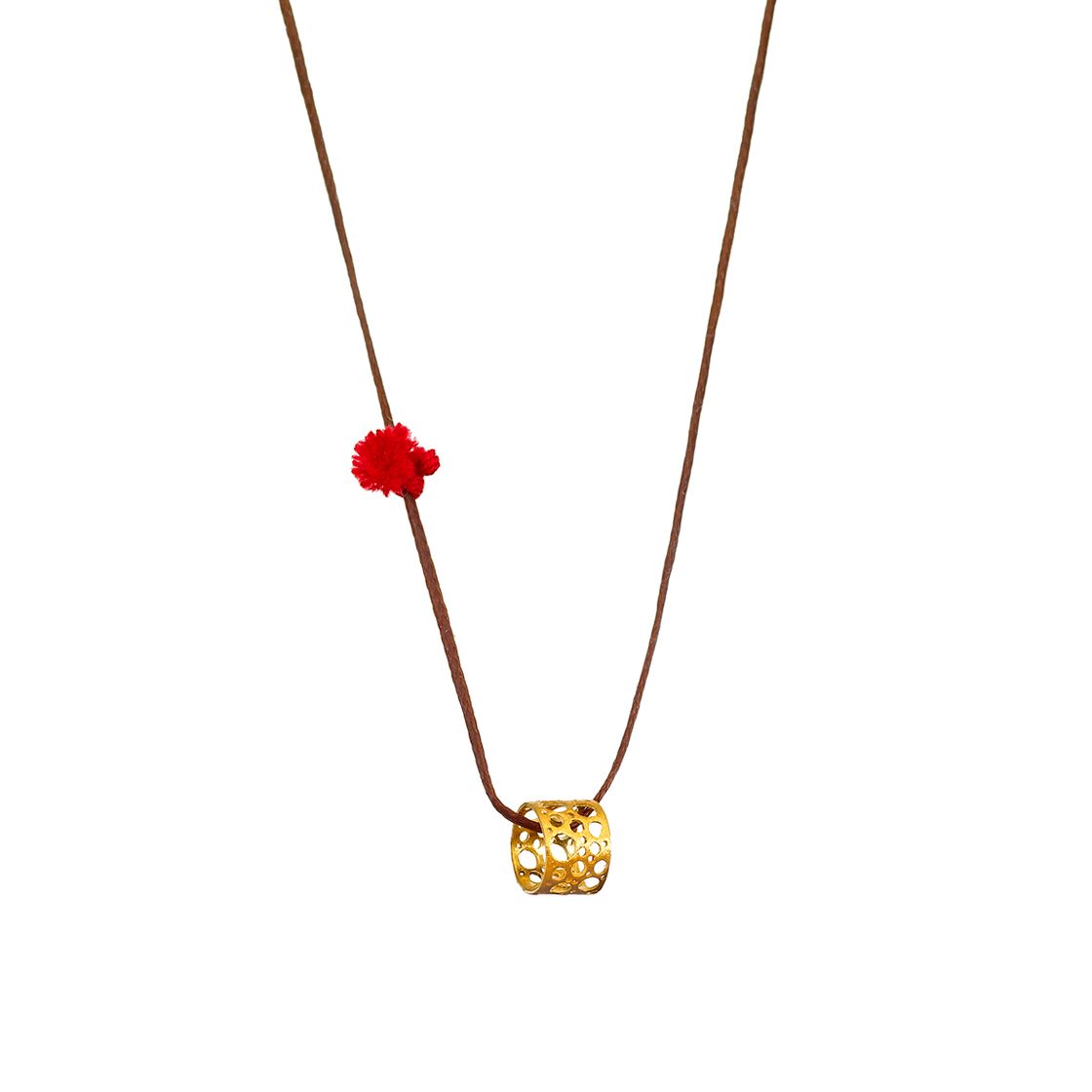Gold lace cuff charm with red tassle on black waxed cord.