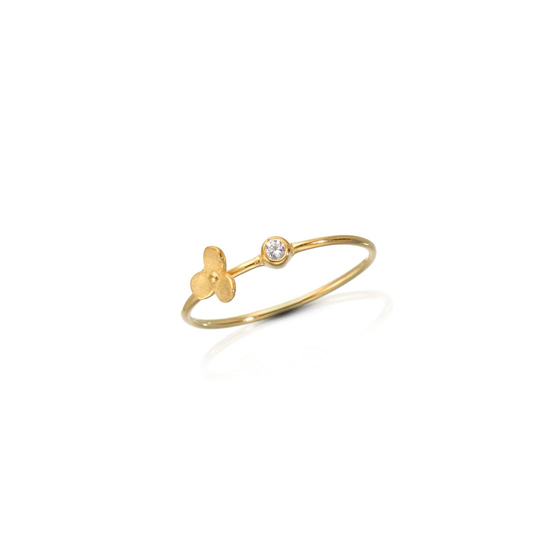 Gold solitare ring set with a round zircon stone and gold clover detail.